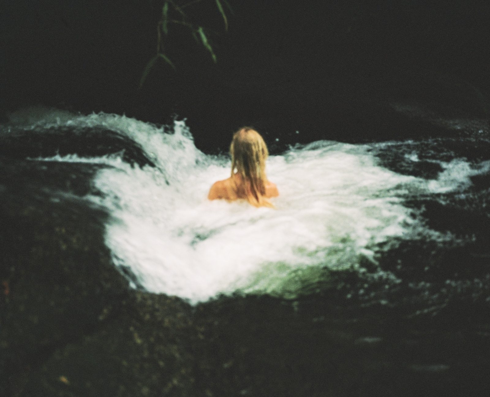 Photograph of a woman in a river, as part of the photography project Are We There by Jenni Toivonen.
